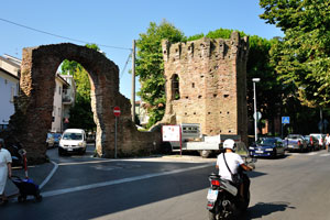 Ancient Roman ruins with the shape of an arch and a tower on the Marecchia street