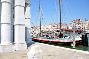 An unusual vessel is docked beside the Punta della Dogana building