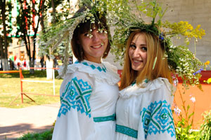 Two girls are dressed in national dresses of white color with a blue ornament