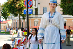 A girl in national dress is on stilts