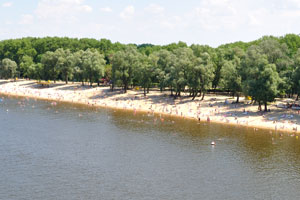 A beach on the Sozh river is full of people in July