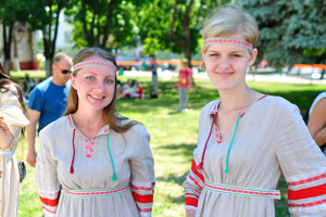 Two Belarusian girls are dressed in national costumes of grey color