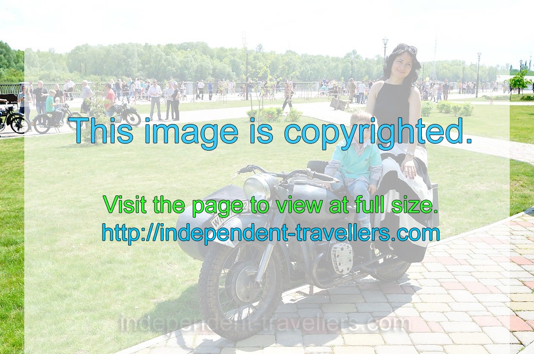 Mother and child pose, sitting on the vintage motorcycle