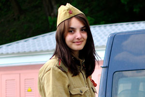 A beautiful belarusian girl is at the field kitchen