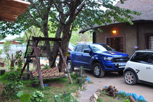 Vehicles are in the courtyard of the Elephant Trail guesthouse
