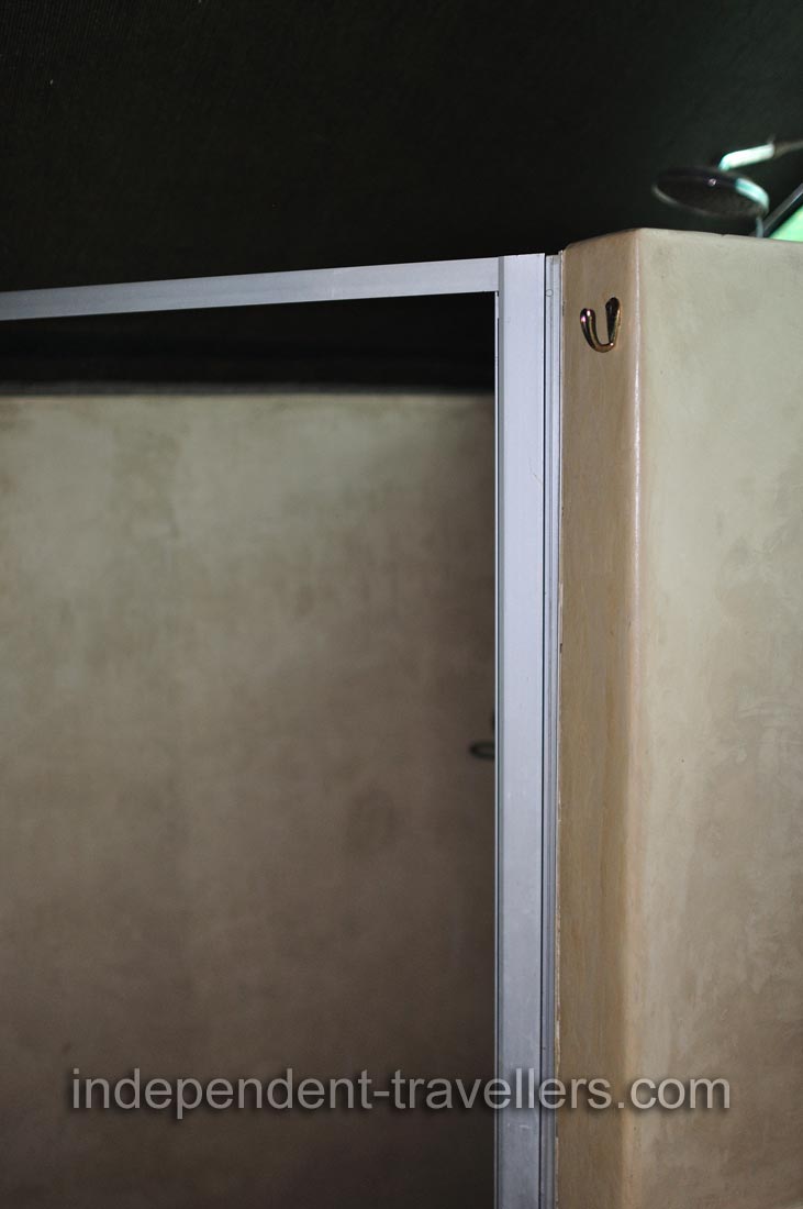 The towel hook is located at the entrance to the shower inside a safari tented room