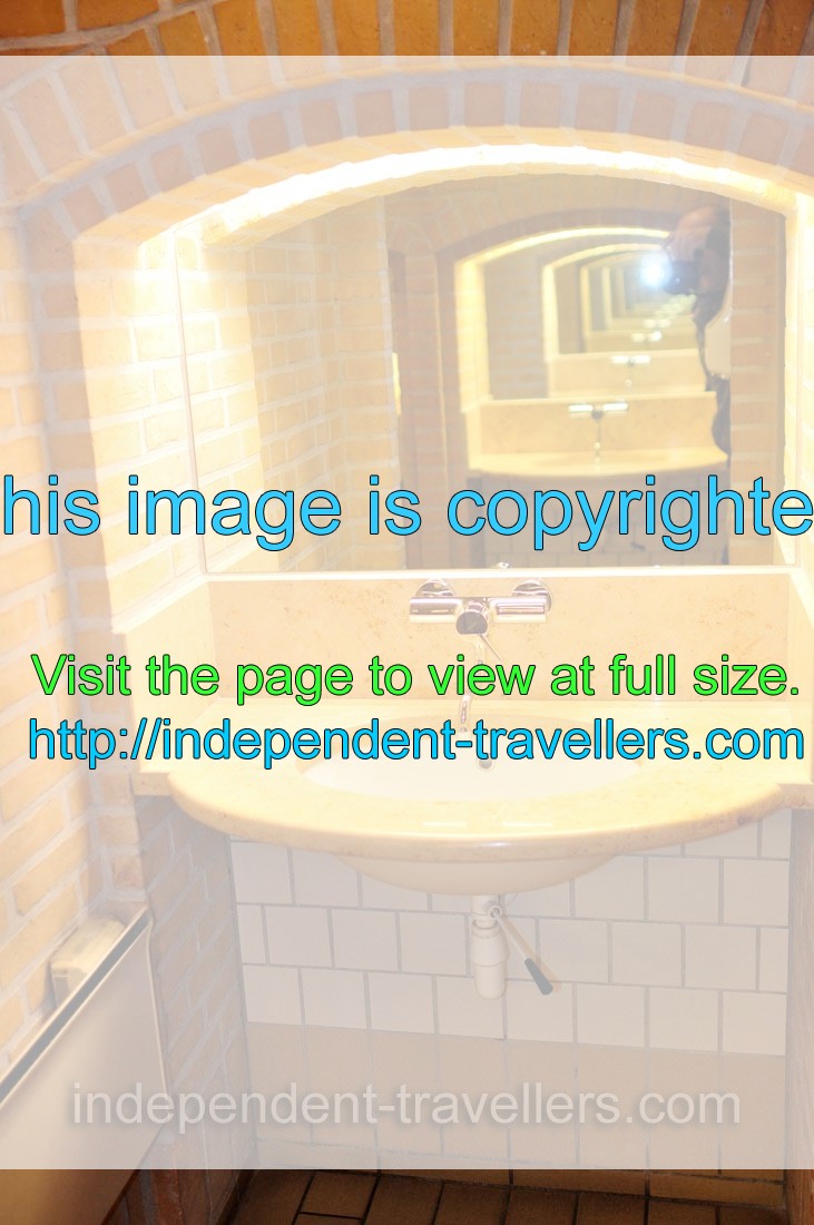 A view in the restroom with parallel mirrors, creating the infinitely repeating wash basins