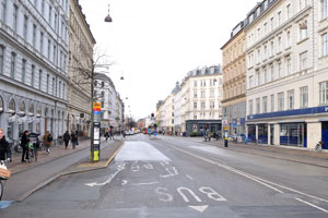 A female cyclist is on Frederiksborggade street