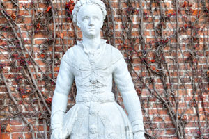 The white statue of a woman is situated beside the Lapidarium of Kings