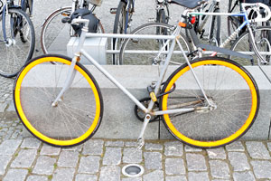 A bicycle with yellow wheels is at the bicycle parking of the Royal Library
