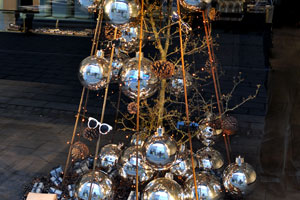 A Christmas shop window display depicts a Christmas tree