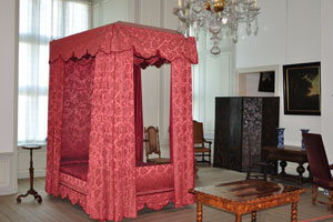 A bed with bright red curtains is in Kronborg castle