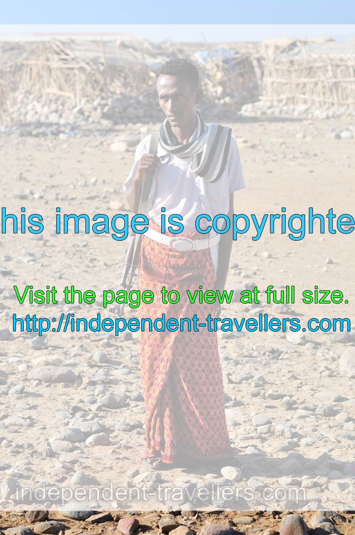 Young Afar man with an assault rifle wears something which looks like the skirt