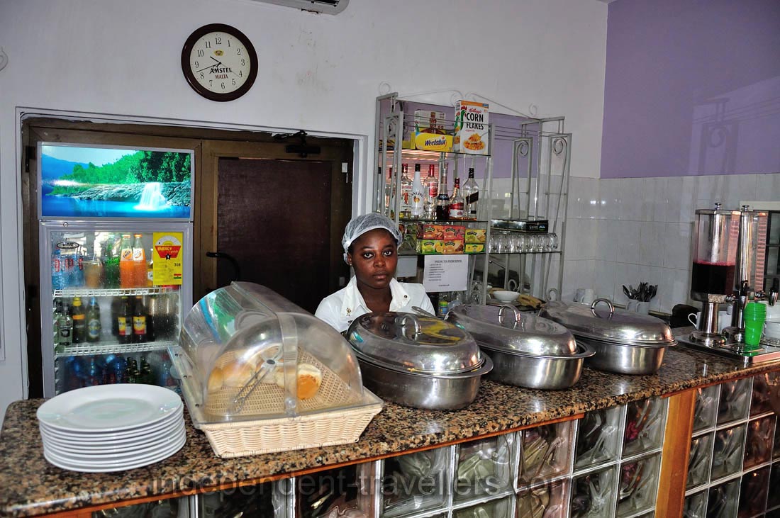A young woman works on the kitchen of the Pink Hostel