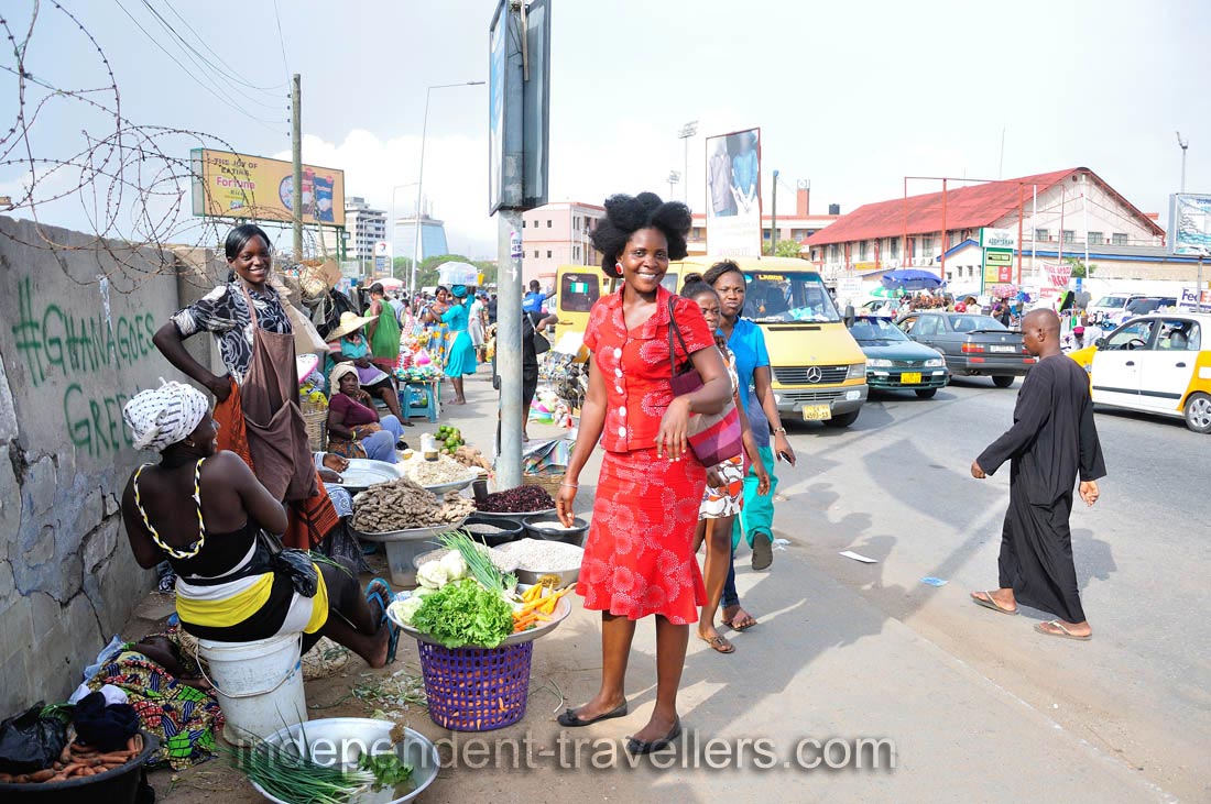 A good-looking woman in the red dress is on the Makola market