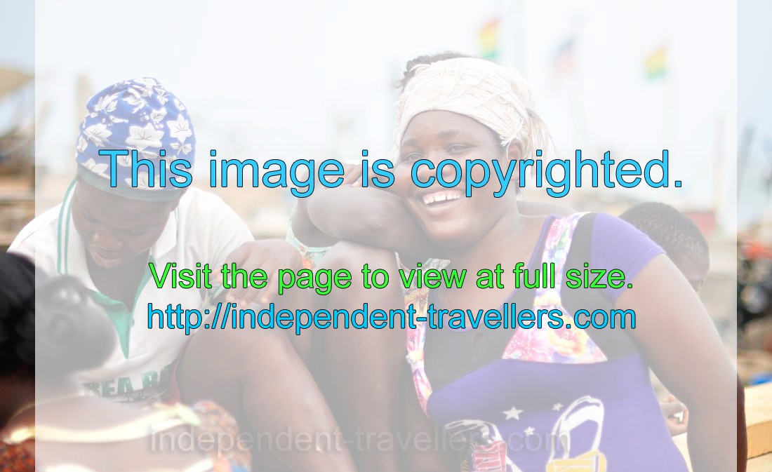 Three African women from the fishing village are smiling