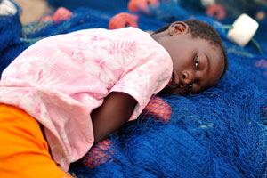 A Ghanaian child is lying on the fishing net