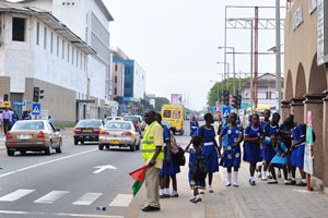 A group of schoolgirls crosses the road close to the building of Cathedral Clinic