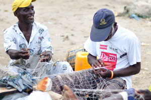 Three fishermen are weaving the fishing nets