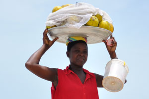 A female fruit vendor puts the plate with fruits on her head