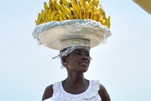 A female vendor of bananas is going to drink the water