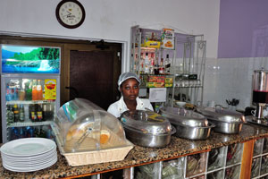 A young woman works on the kitchen of the Pink Hostel