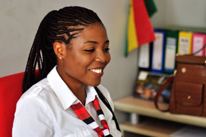 A smiling Ghanaian girl is in one of the car rental agencies