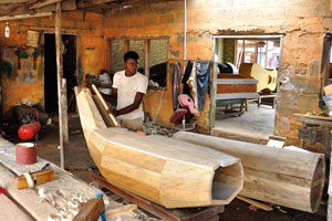 A carpenter at work is planning a coffin in the Kane Kwei Carpentry Workshop
