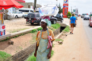 A young woman is a street vendor of drinking water