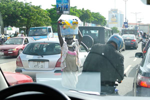 Street vendor works in the traffic jam