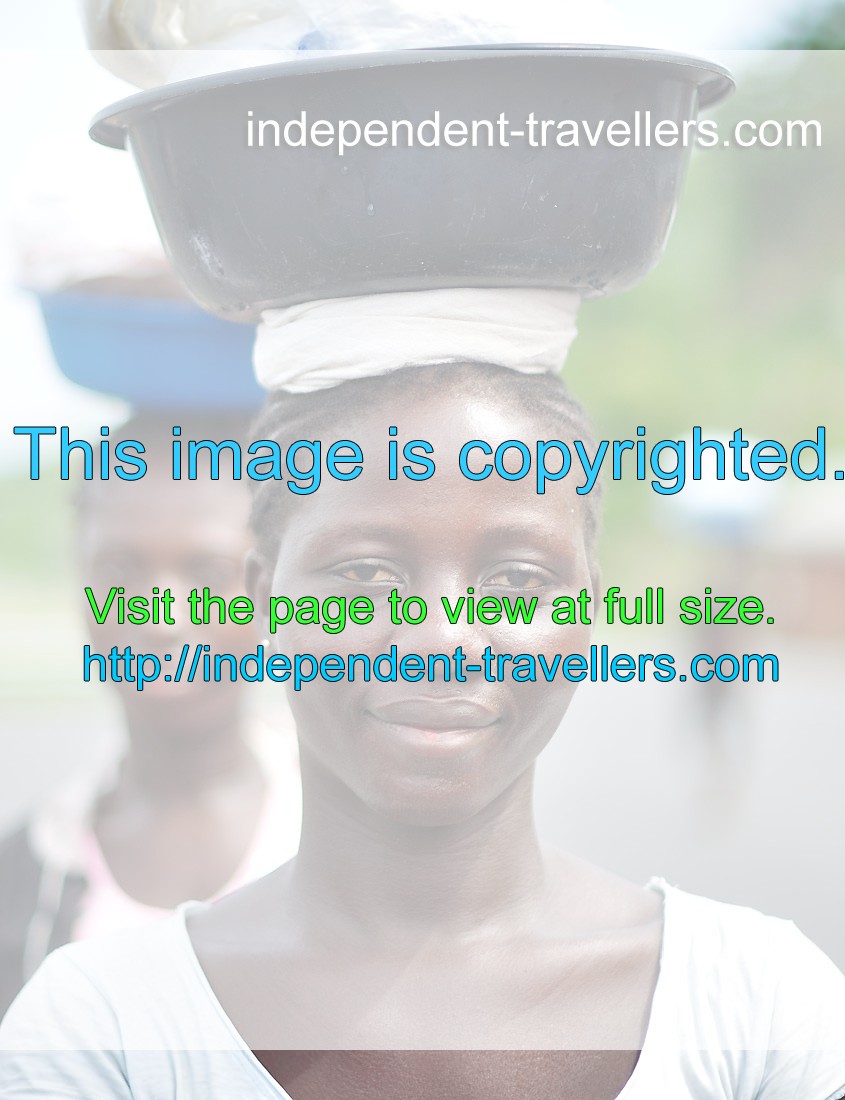 A pretty Ghanaian girl is portrayed with a basin on the head