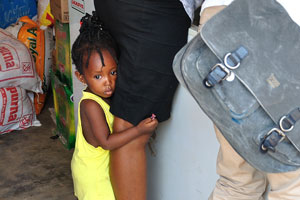 A cute little Ghanaian girl is hugging mother's legs