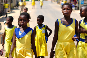 Schoolgirls are dressed in long yellow dresses