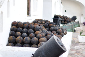 Ancient cannons and cannonballs are in the Cape Coast castle