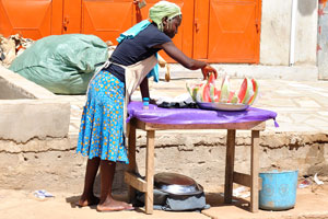Female vendor sells slices of watermelon on the street