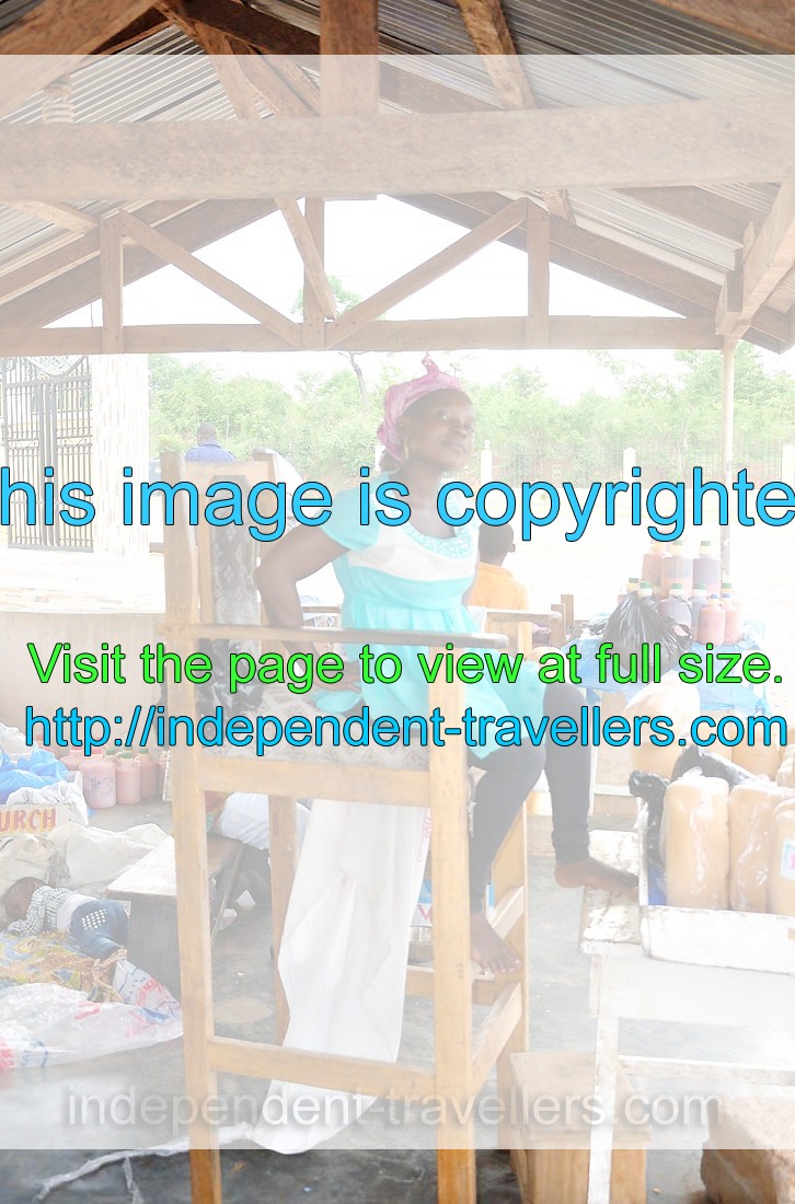 A good-looking female vendor sits on the high chair in a haughty pose