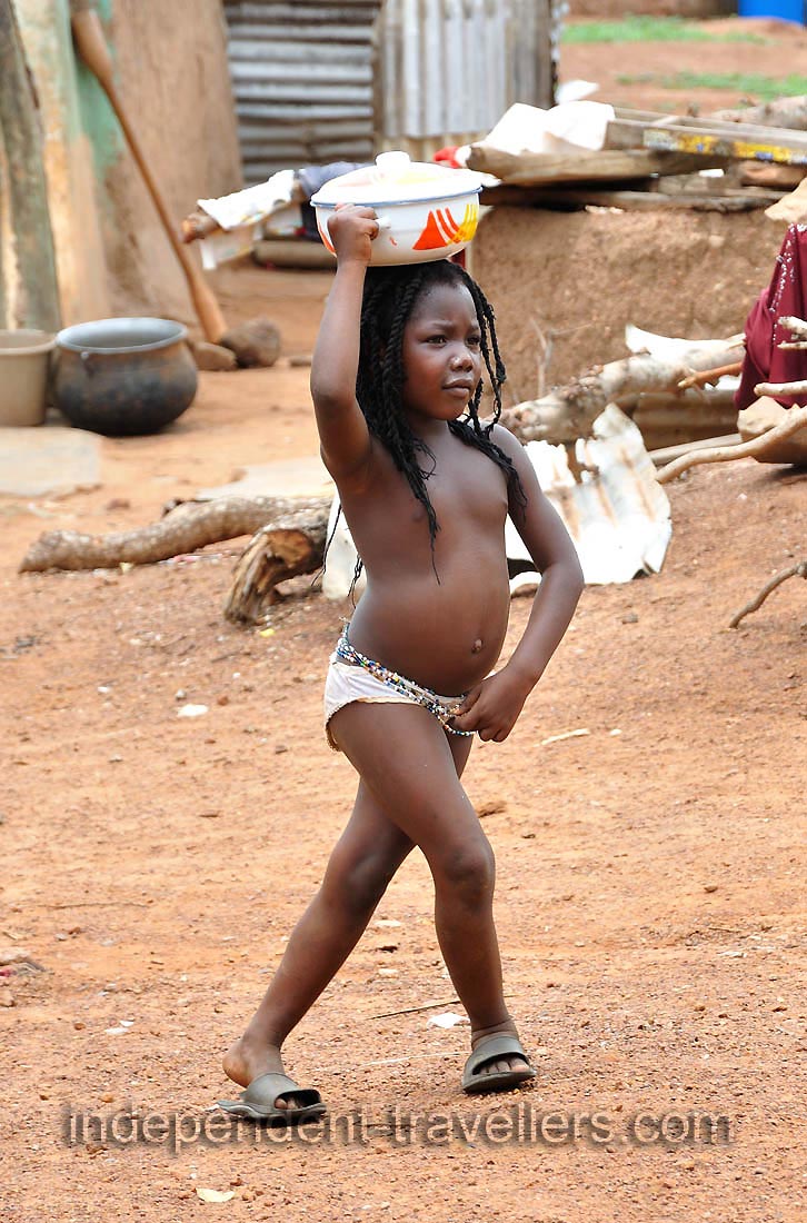 A little girl walks through the village of Larabanga