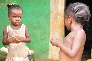 Two cute little African girls, one of them wears the belly beads without panties