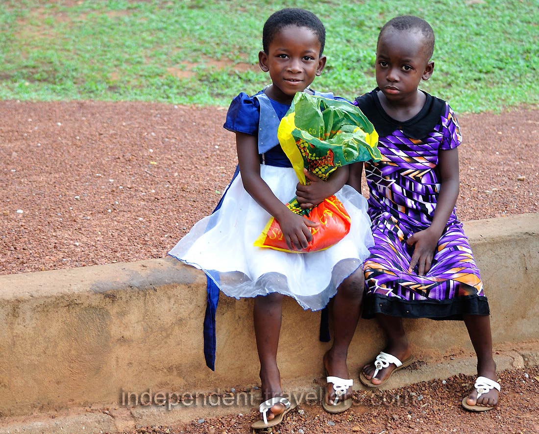 Two cute little African girls are at the entrance of park