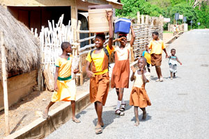 Schoolgirls walk home after school through the street of Tafi Atome
