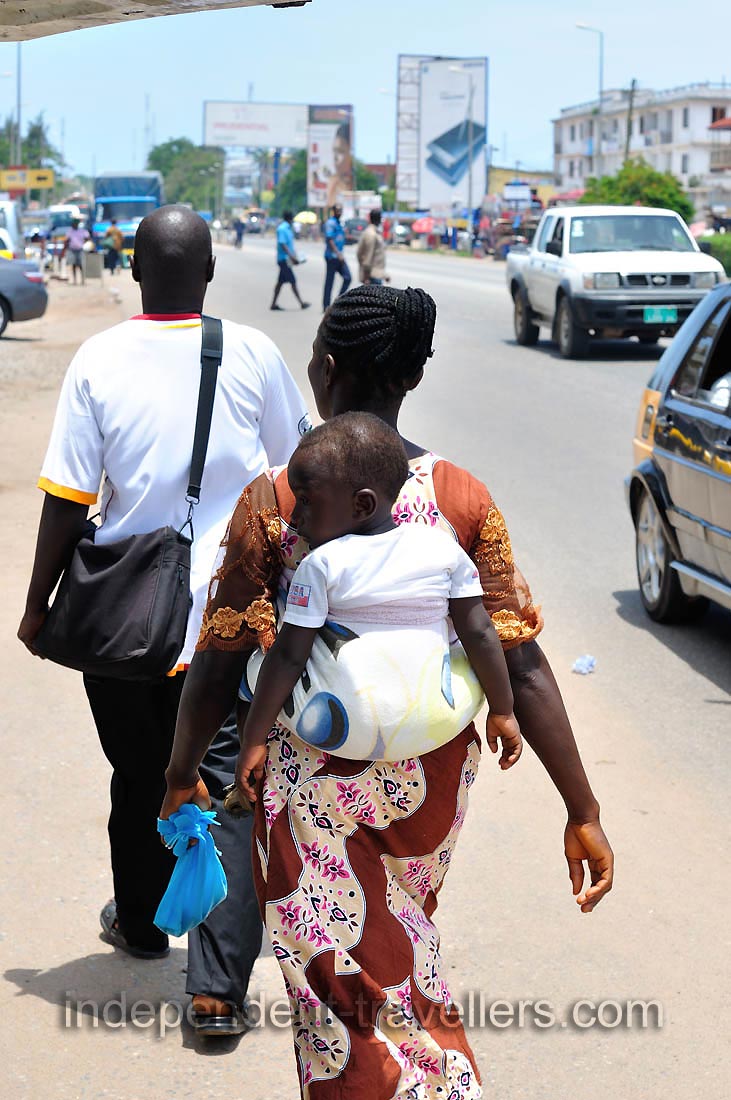 A woman is carrying the baby on the back