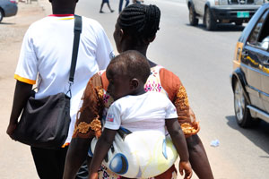 A woman is carrying the baby on the back