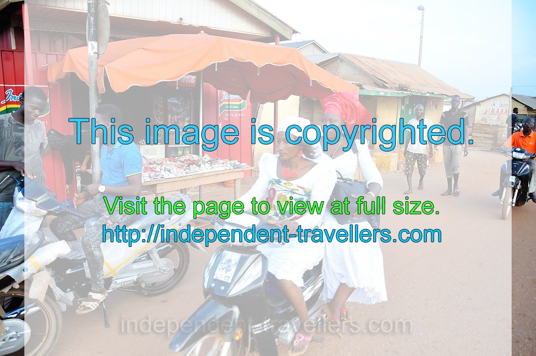 Two women are traveling on the motorcycle in Tamale