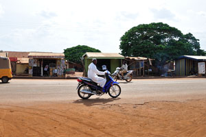 Muslim man is travelling on a motorcycle in Yendi