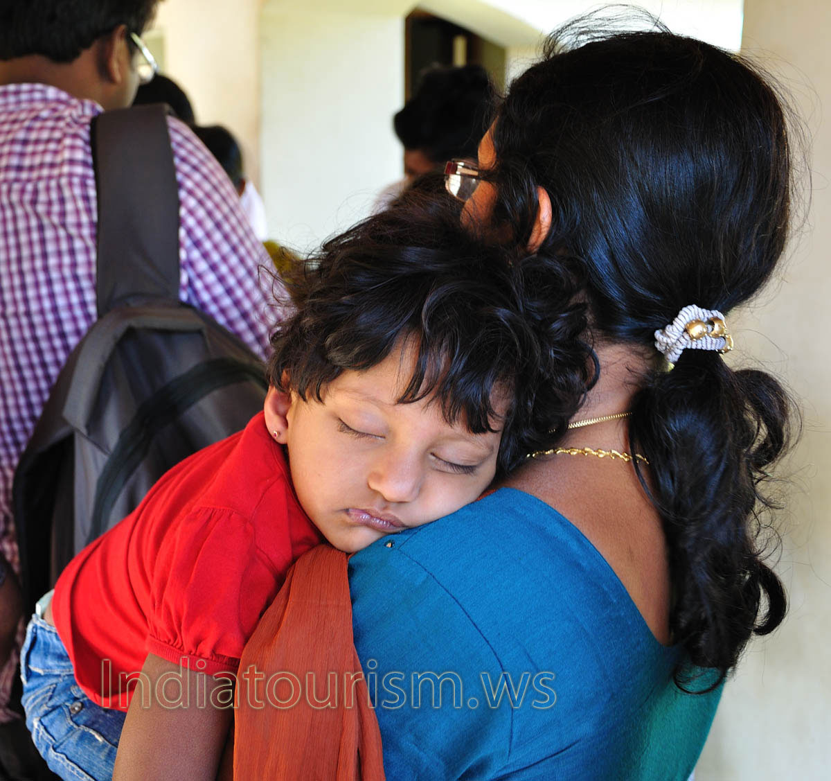 baby sleeps on the shoulder of the mother