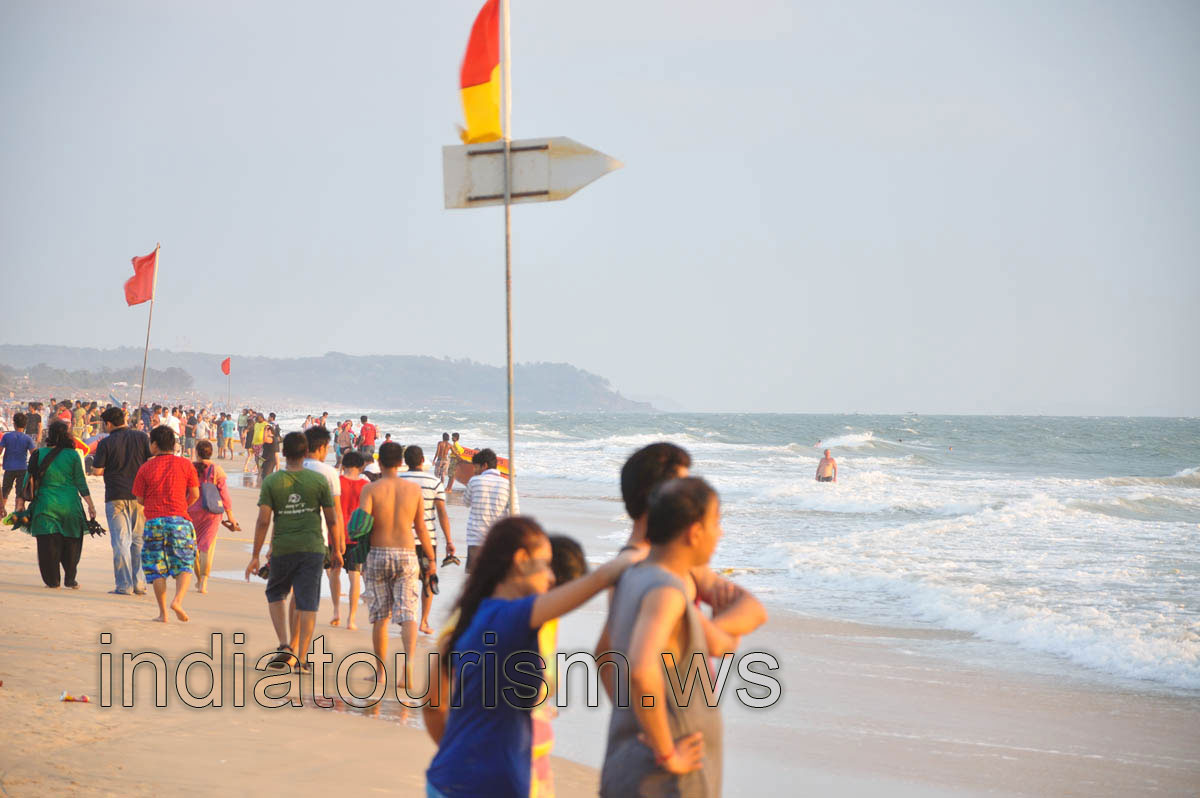 People walk along the ocean shore before the sunset