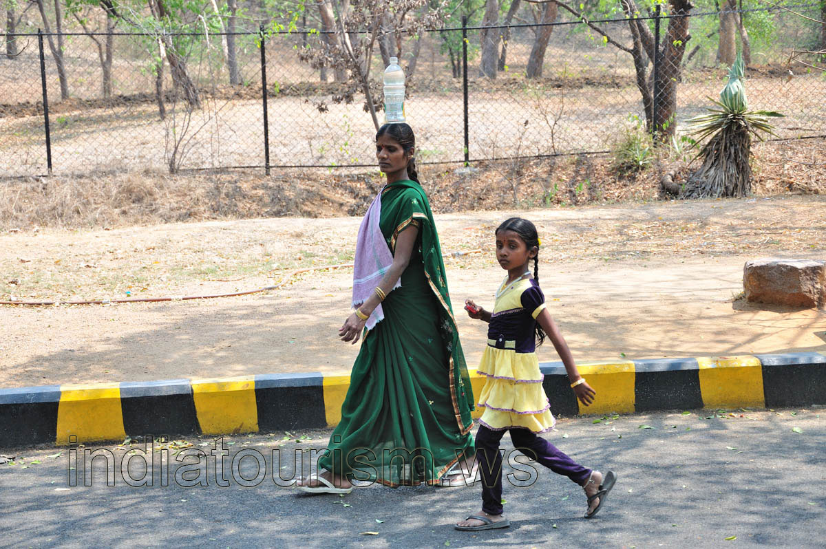 Indian woman with a plastic bottle on her head
