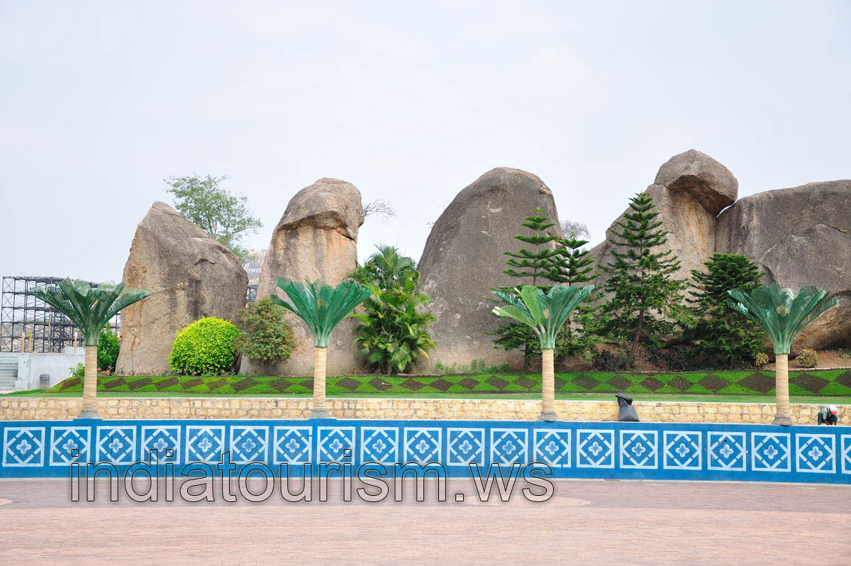 Landscape design with an artificial palm trees and a huge stones