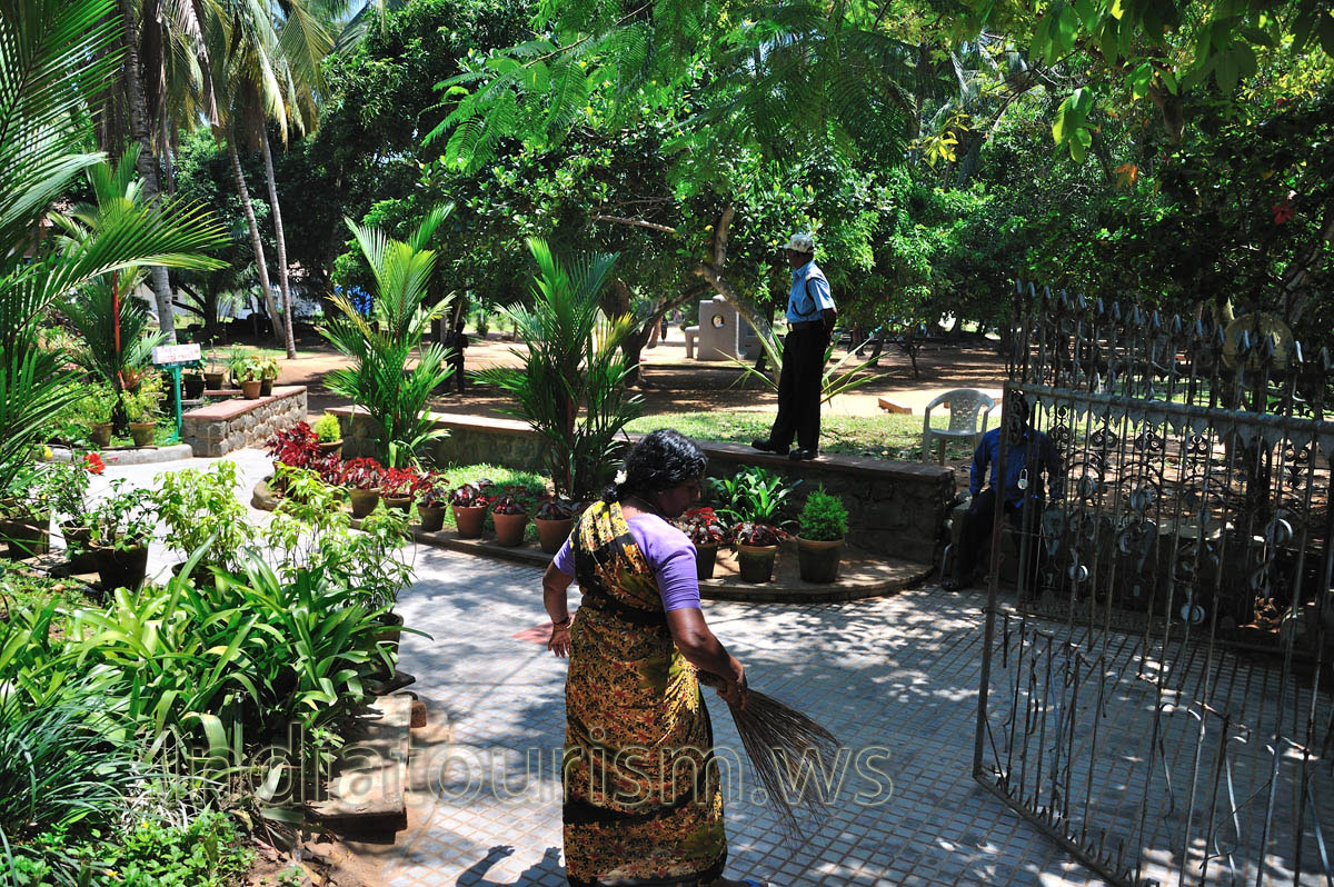 woman sweeps the alley at the entrance to veli