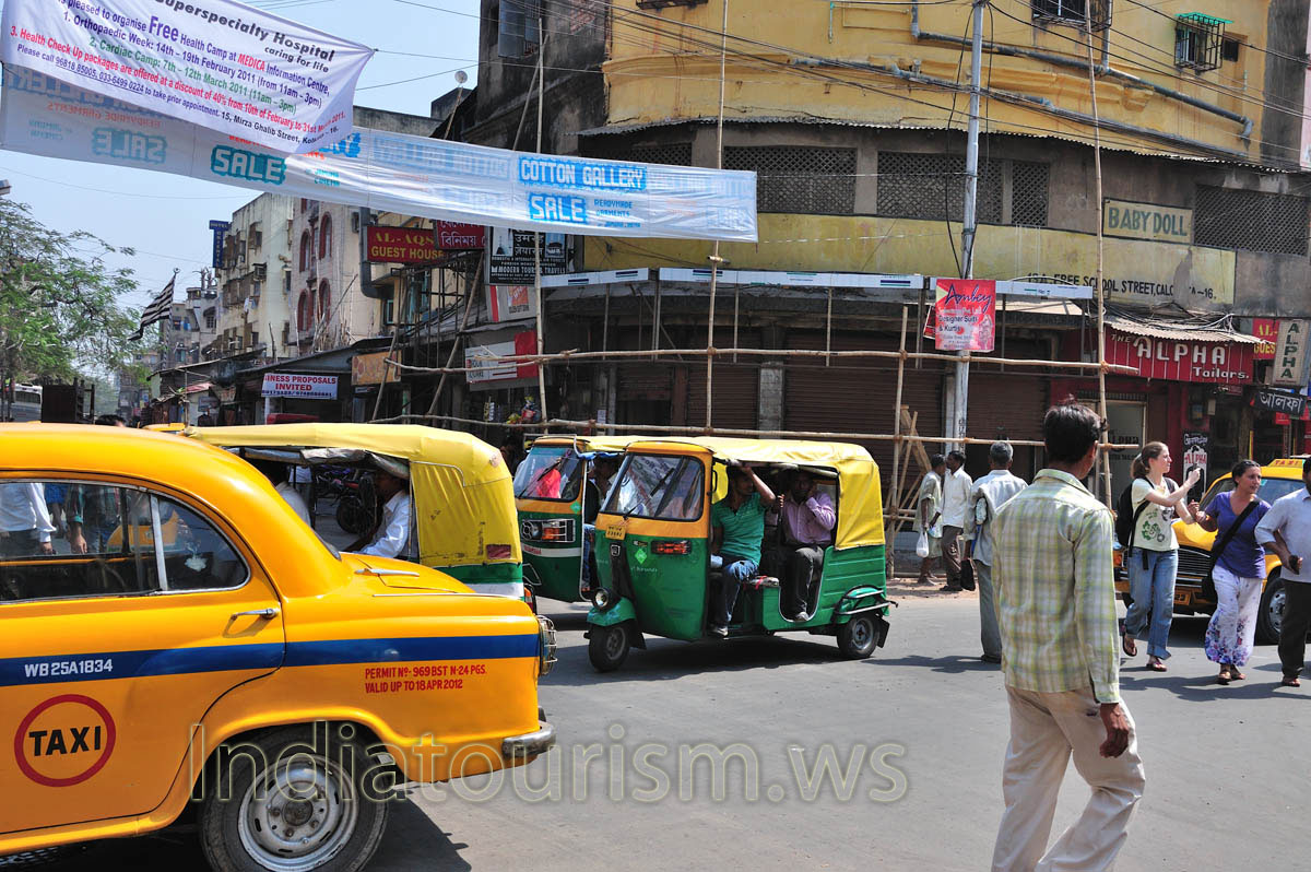 The crossroad is full of taxi and autorickshaws